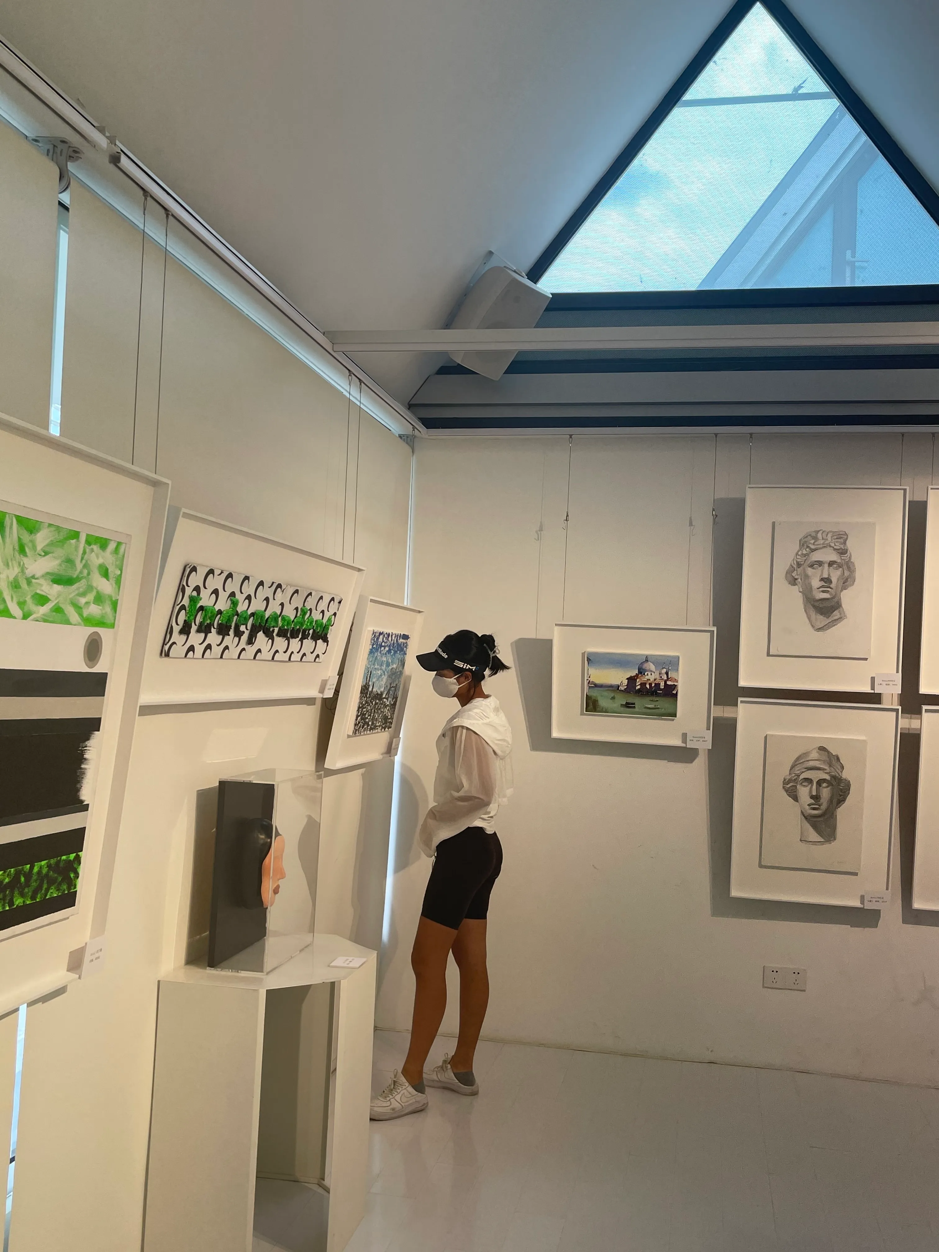 Gallery view — visitors among paintings and vitrines